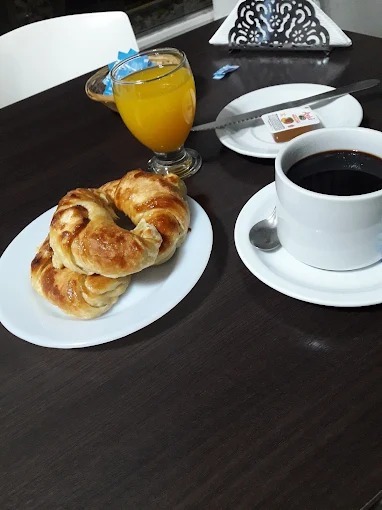 Desayuno en el hotel: medialunas, jugo de naranja y café
